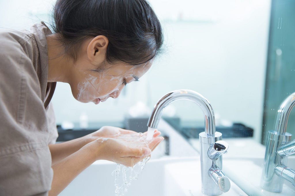 An individual washes their face.