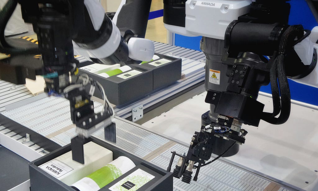 A robot hand in a factory sealing a box on an assembly line