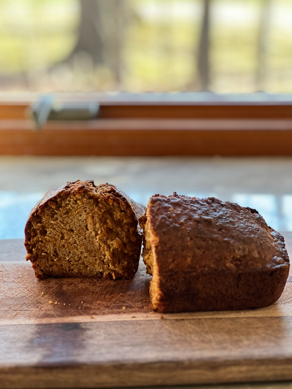 Apple carrot bread on a wooden board in front of a window