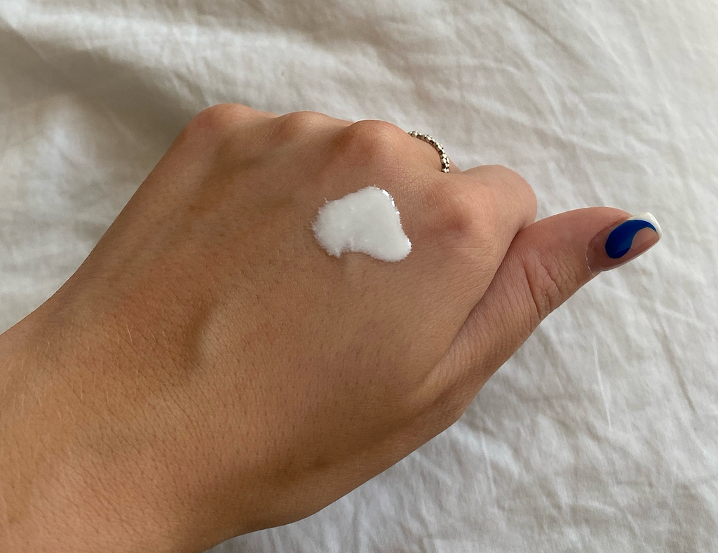 Image of a hand with a ring on the third ringer. On the hand is the SPF liquid that is meant to show the consistency of the liquid.