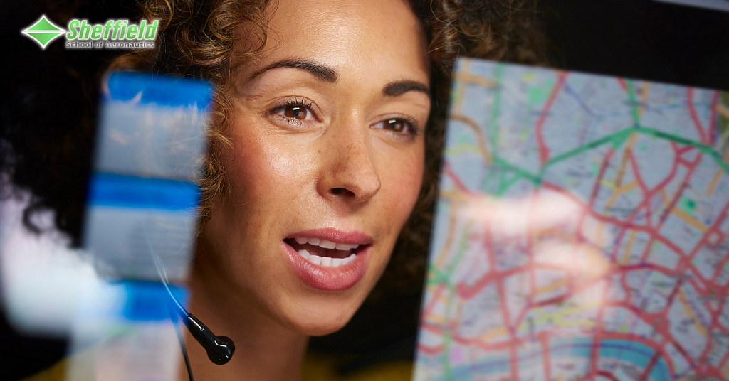 A woman with brown, curly hair is wearing a headset. She seems to be looking at a map of flight paths and the sky at the same time. This indicates she is a flight dispatcher, and the article describes this line of work.