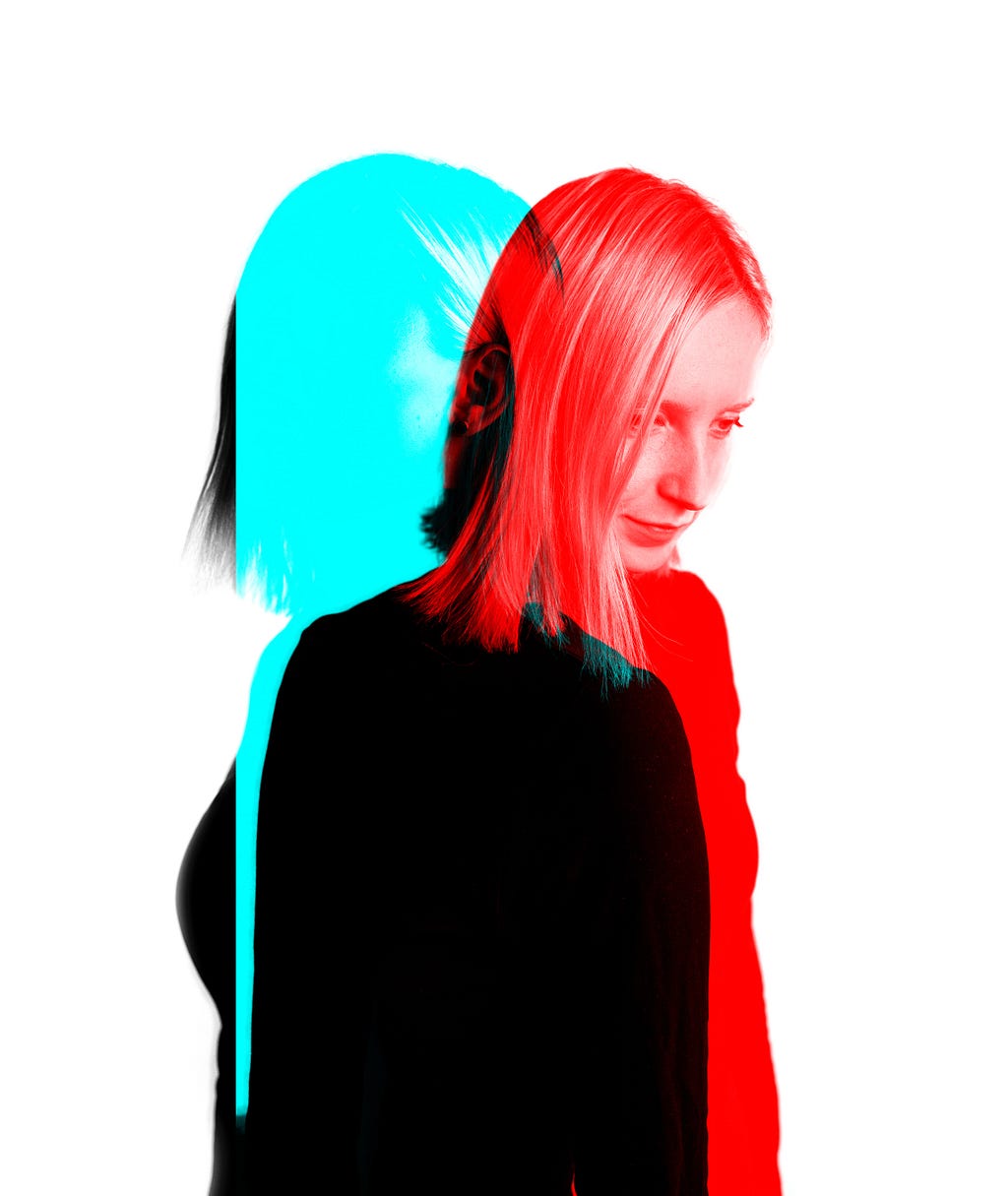 A duotone photo of a woman isolated on a white background. The image has been split, to depict the women in blue on the left and a women in red on the right. Where the two images intersect, the combined colouration is black.