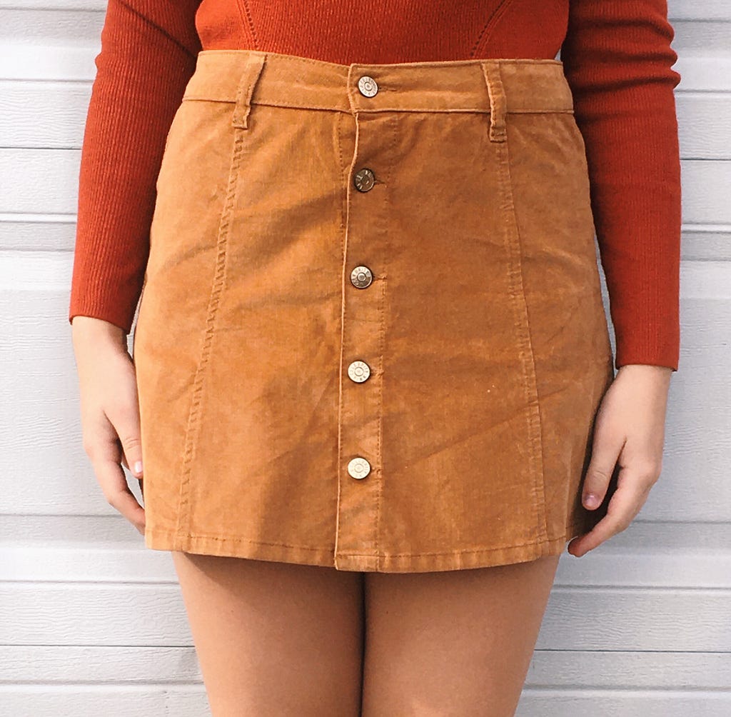 A brown buttoned down corduroy miniskirt worn with an orange sweater. Worn by me.