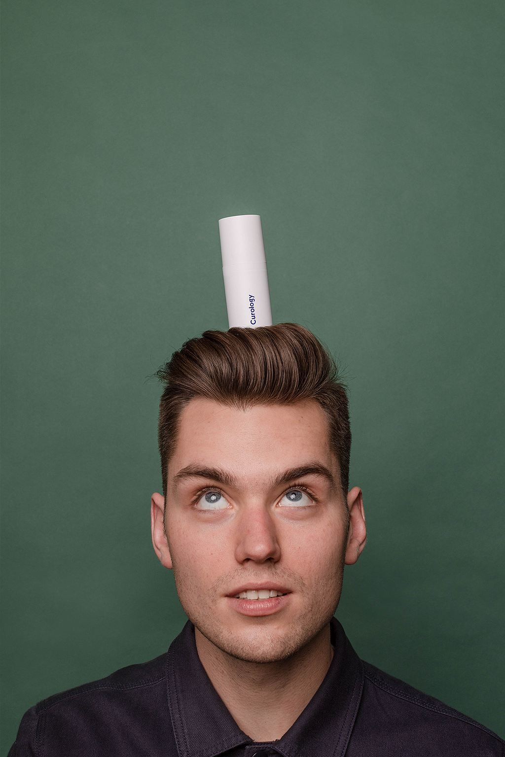 Person balancing a Curology custom superbottle on top of their head