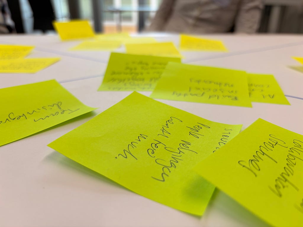 Several green post its switch scribbles on a table.