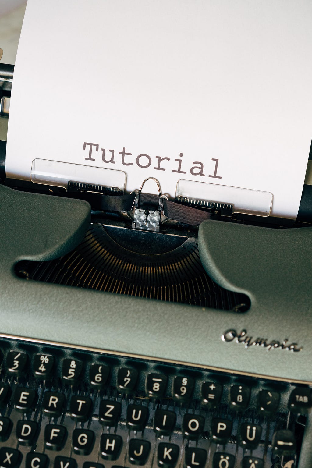 Máquina de escrever com um papel digitado com a palavra Tutorial.
