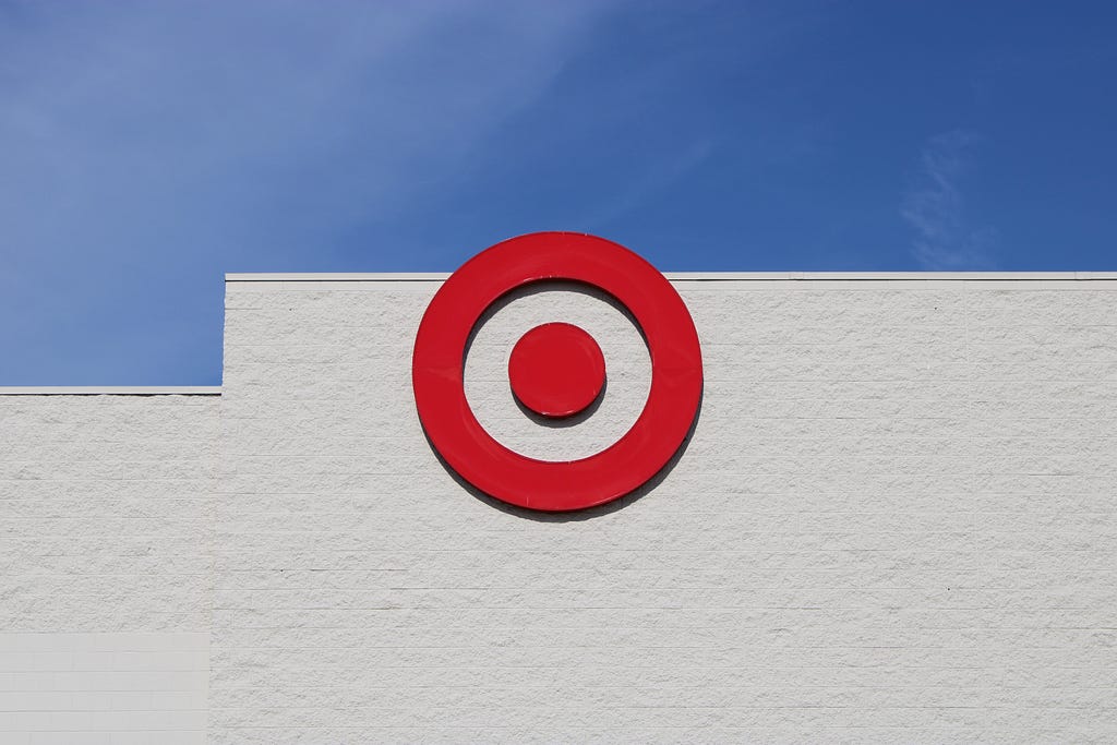 Targets Logo on a building against a blue sky. Or A red bullseye on a grey concrete buliding against a blue sky.