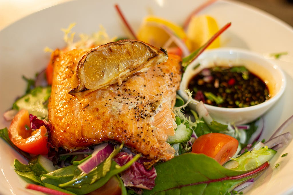 Salmon dinner on top of a salad