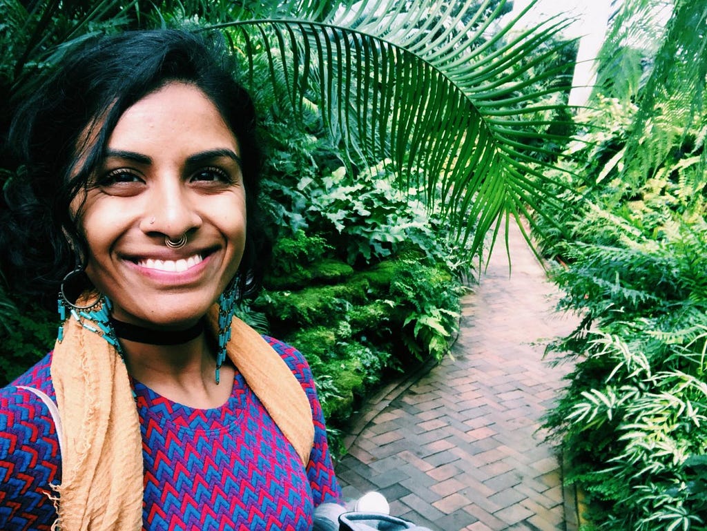 photo of Meena Kaushik in front of lush green foliage