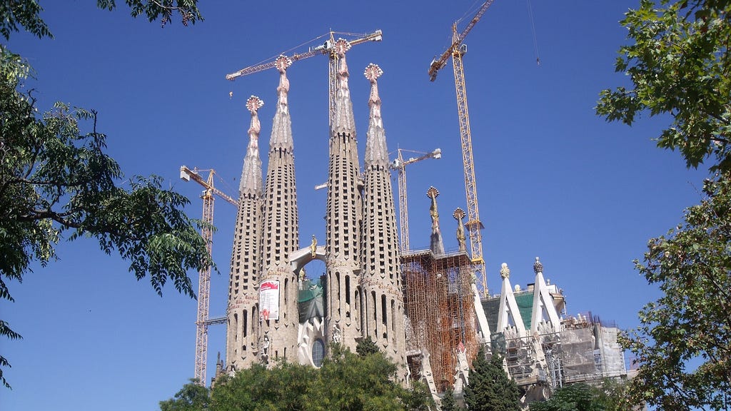 The Sagrada Família stands tall amidst a backdrop of blue sky.