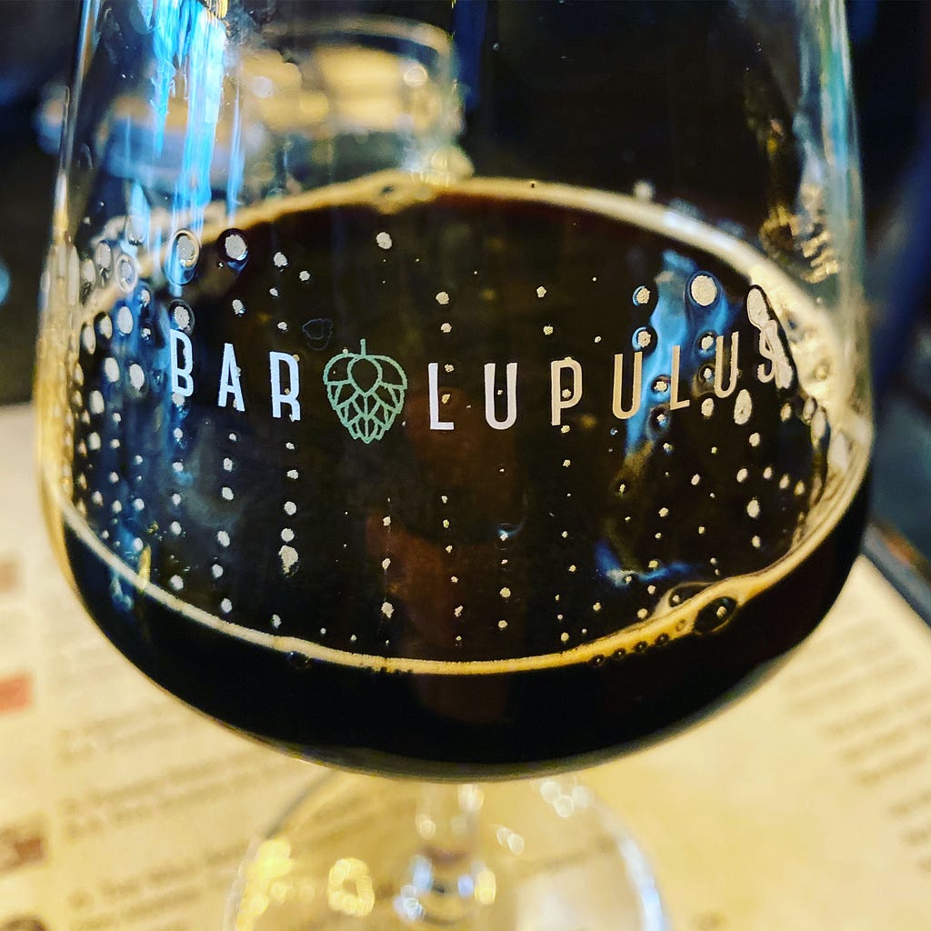 Picture of a glass of stout with Bar Lupulus printed on the glass