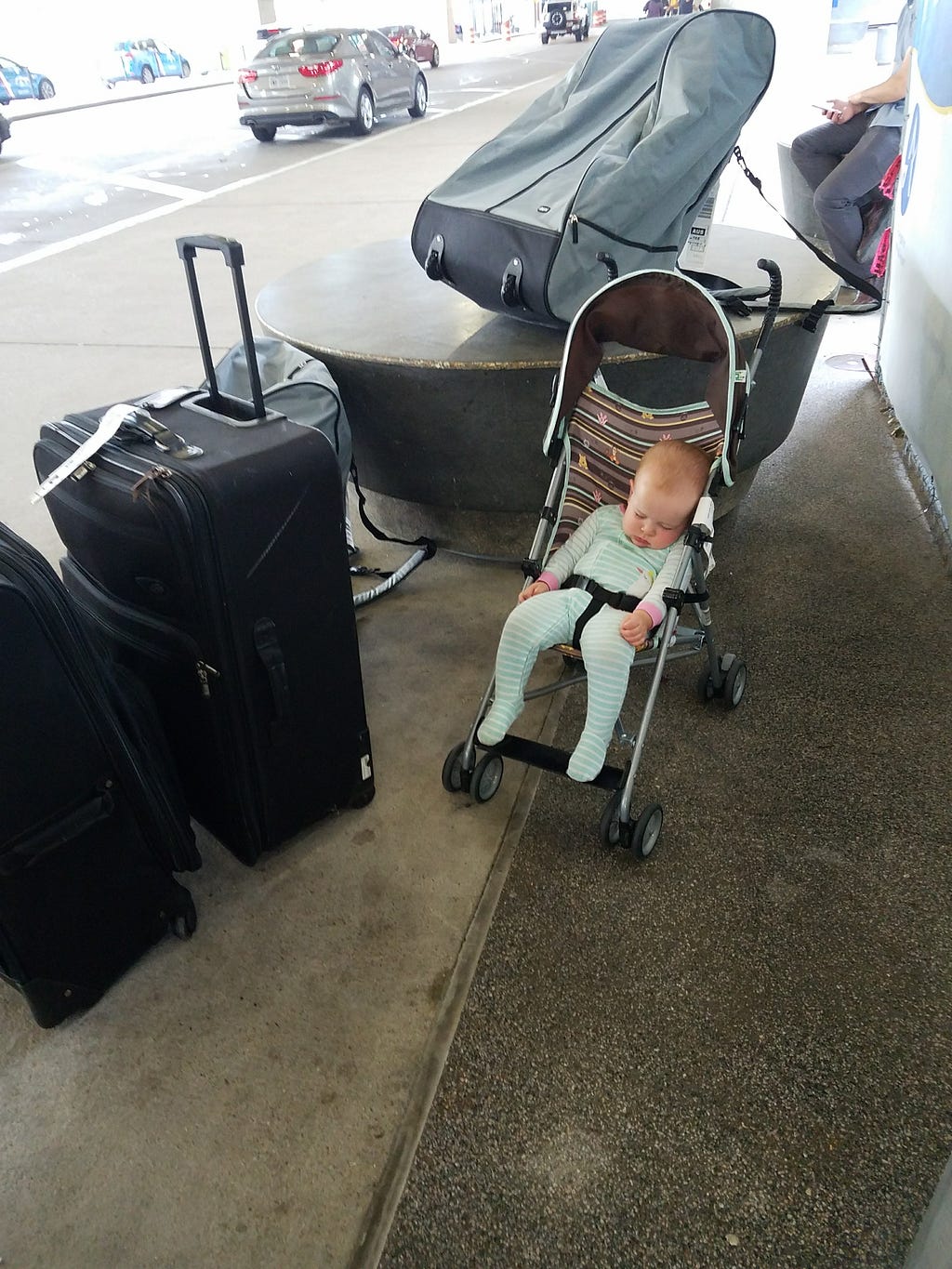 Waiting outside baggage claim after our first family flight, with a metric ton of luggage and one sleeping baby. Not pictured: the screaming baby.