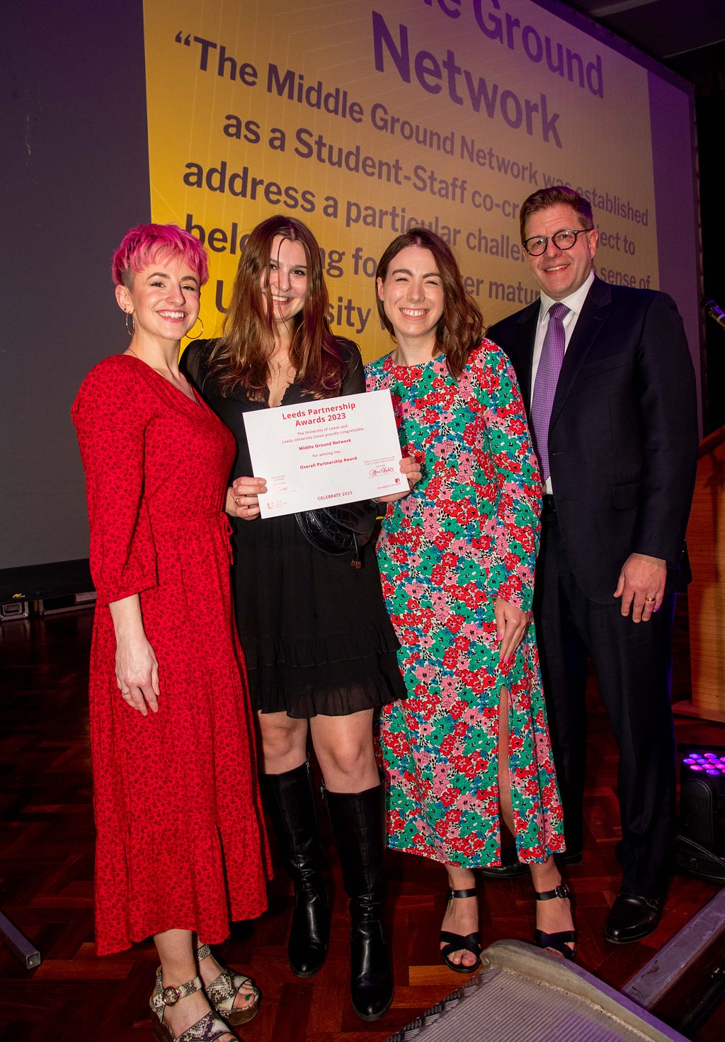 Lauren (Student Experience Officer), Zofia (Middle Ground Network Engagement Coordinator), Laura (Student Success Officer) and Jeff (DVC Student Education) stood on the stage at the Partnership Awards after receiving the Overall Partnership Award