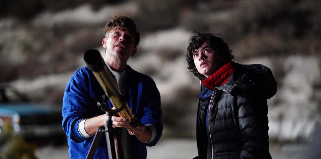 Dante and his father, Sam Quintana, looking up at the night sky with a telescope nearby.