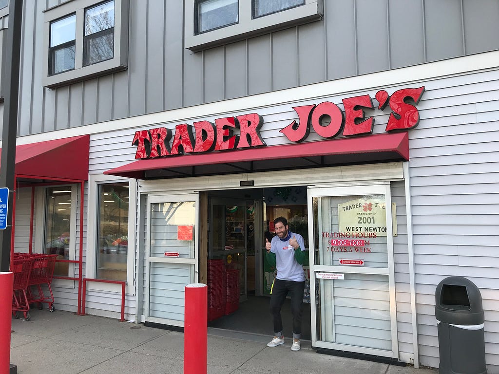 Trader Joe’s storefront a typically enthusiastic Trader Joe’s employee giving a thumbs up in the doorway