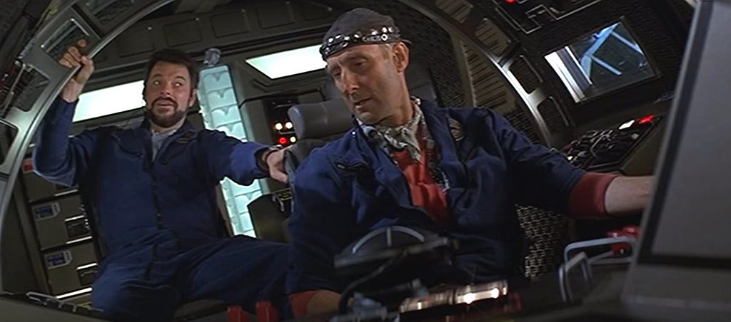 Two men talking to each other in the cockpit of a rocket ship, from Paramount Pictures’ 1996 film Star Trek: First Contact