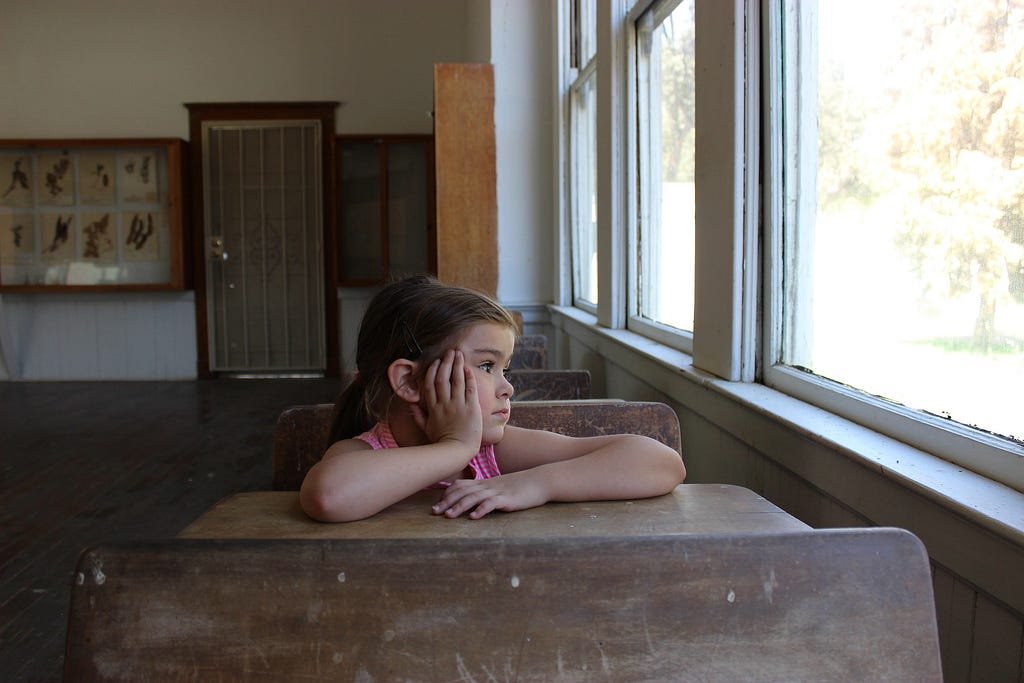 Child in classroom looking out of window