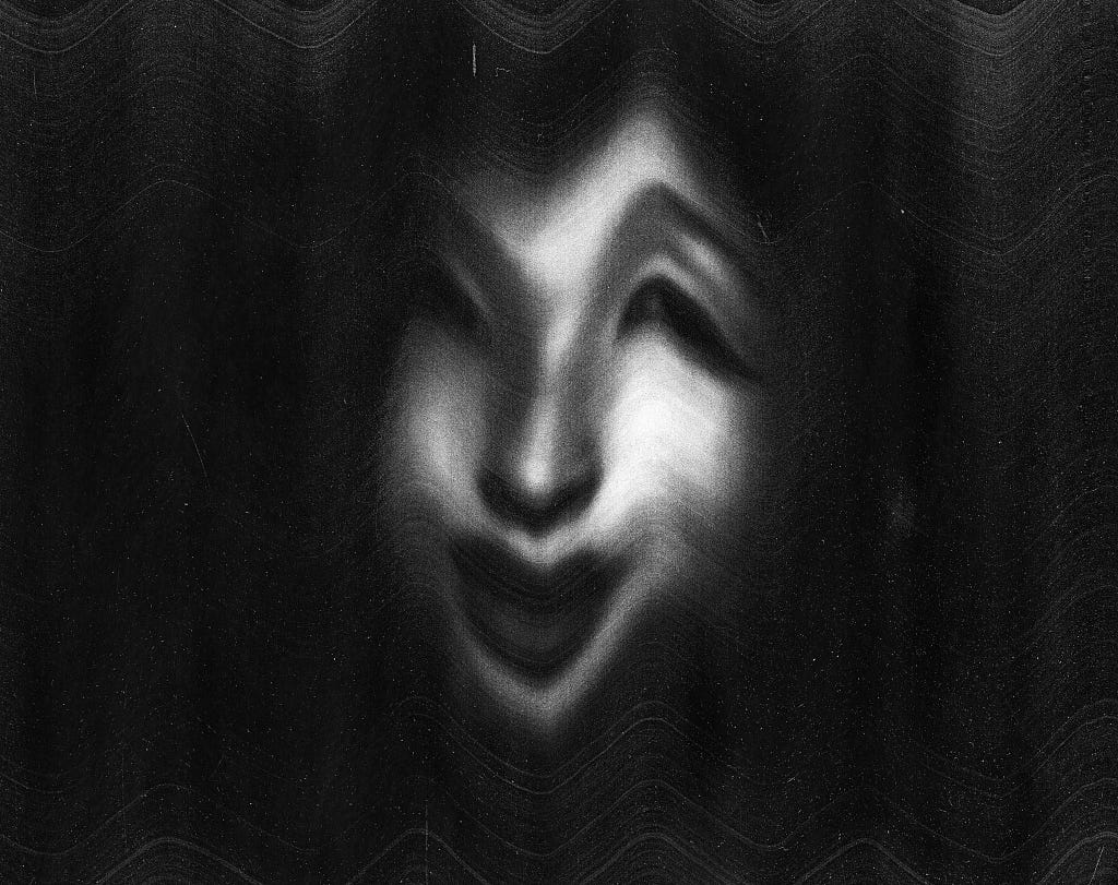 Distorted, black and white image of a woman smiling