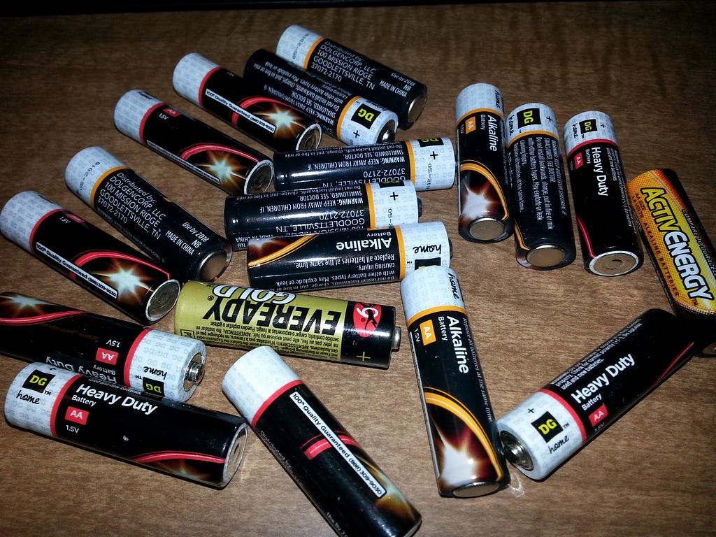nineteen AA batteries of various brands lying on a table