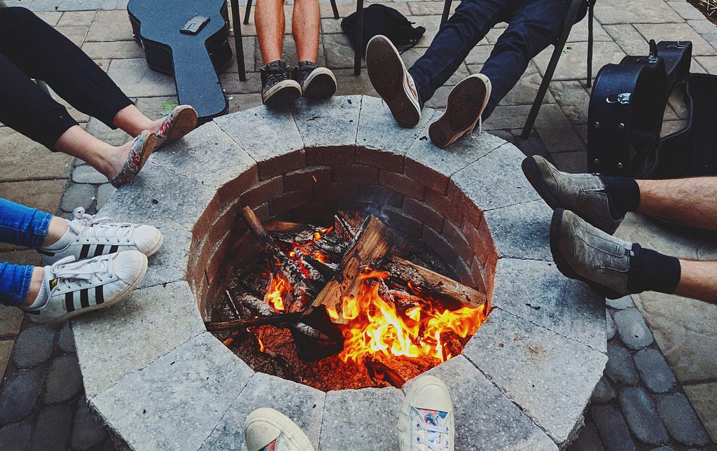 Photo of friends with feet by the fire by Elijah Boisvert on Unsplash