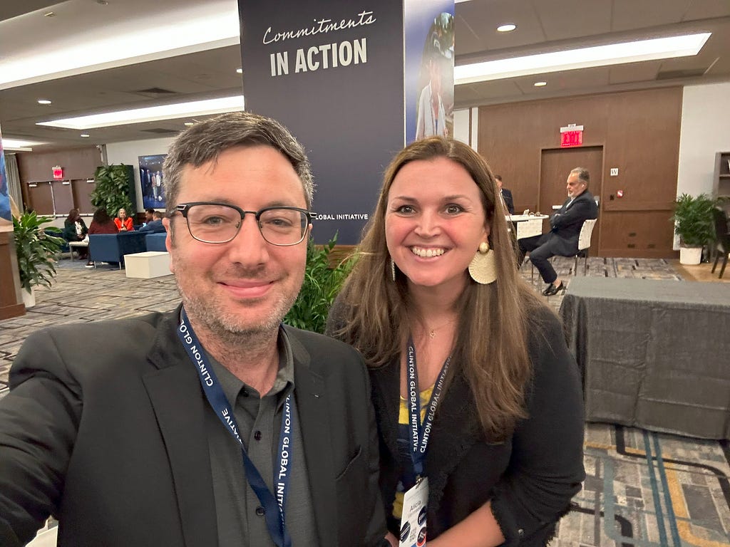 Joe stands next to Alicia Vermaele at CGI23. Both are smiling at the camera.