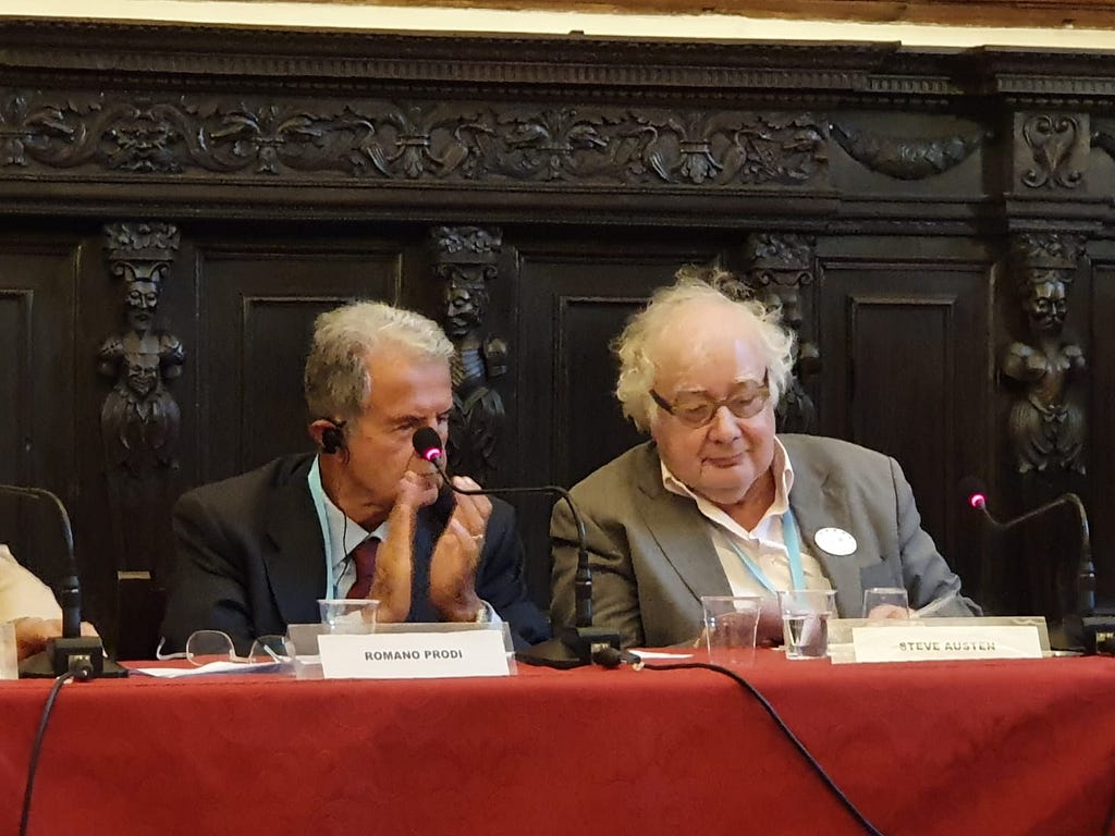 Foto of Romano Prodi and Steve Austen sitting at a table in a conference stetting with microphones. Picture by Ravenna.