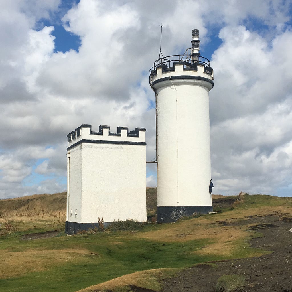 A lighthouse against a wild blue summer Scottish sky
