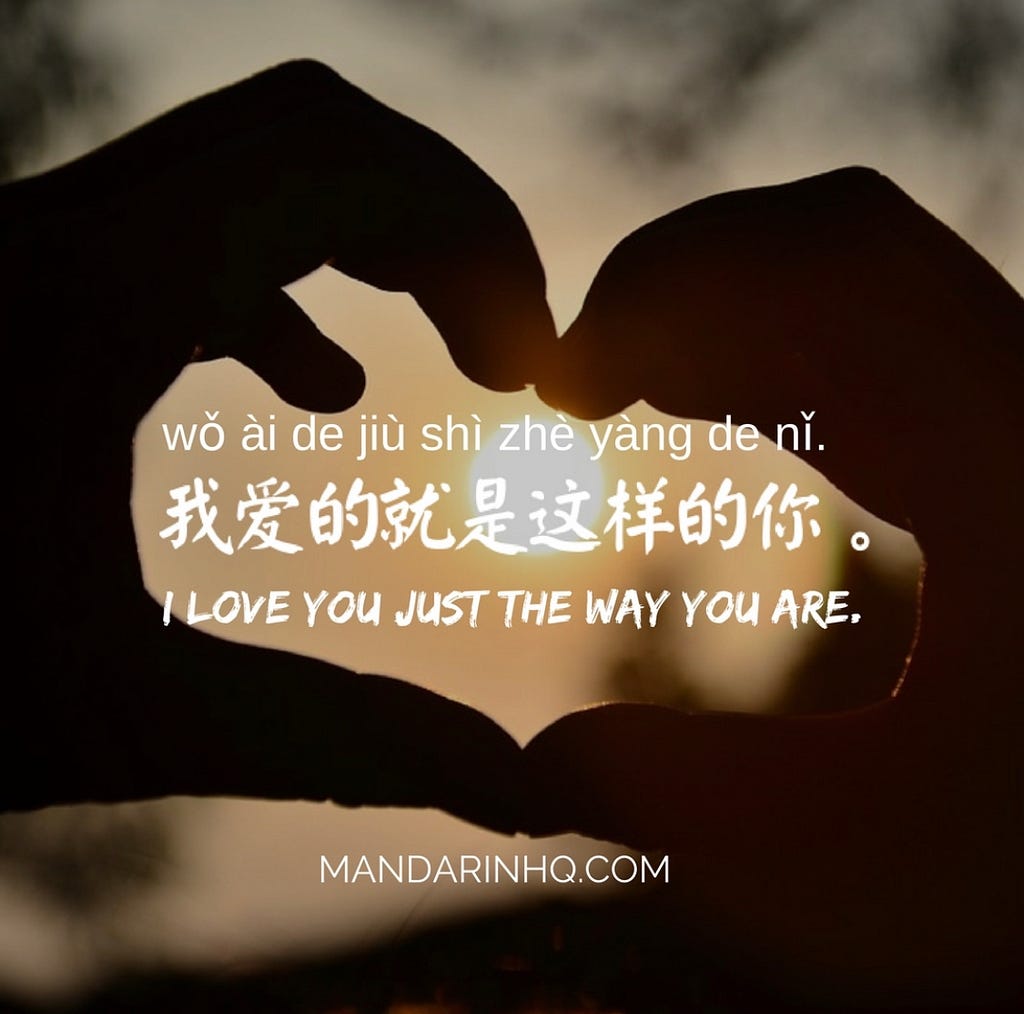 Two hands meet and fingers form a heart shape. The phrase “I love you just the way you are” appears in English and Chinese inside the heart space.