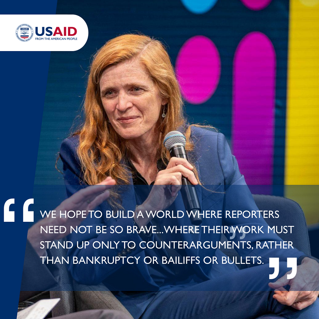 USAID Administrator Samantha Power leans to her right while sitting in a chair and holding a microphone. A quote below the image states: “We hope to build a world where reporters need not be so brave … Where their work must stand up only to counterarguments, rather than bankruptcy or bailiffs or bullets.