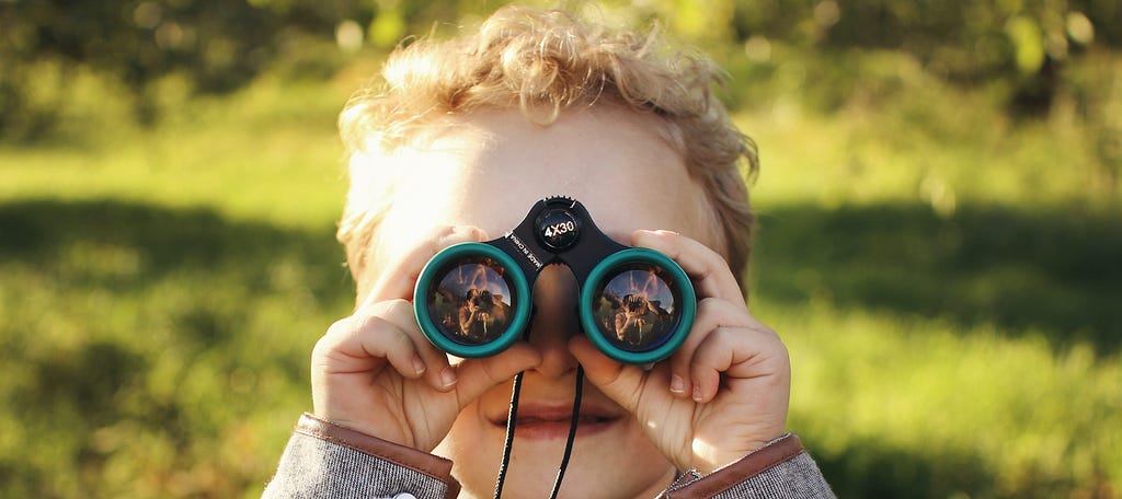 Boy looks through binoculars