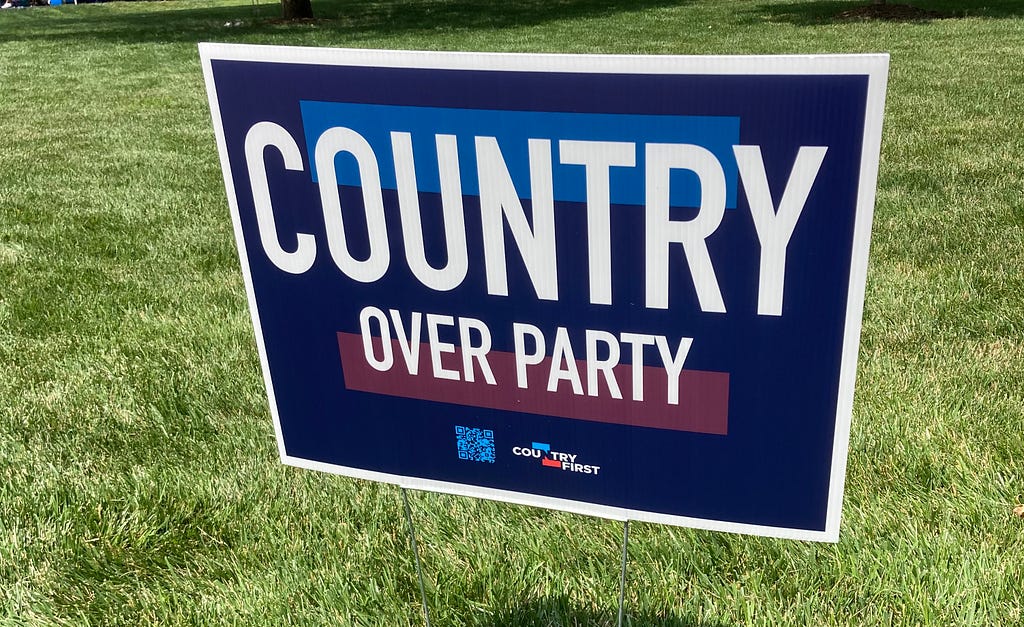 Yard sign, blue and red, saying “COUNTRY OVER PARTY,” with the word “Country” over and much larger than the rest. (Photo by author.)