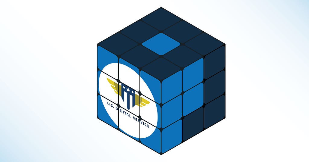 A Rubik’s cube with blue and dark blue squares. Two sides spell the number 9 in cubes and the front side has the logo for U.S. Digital Service.