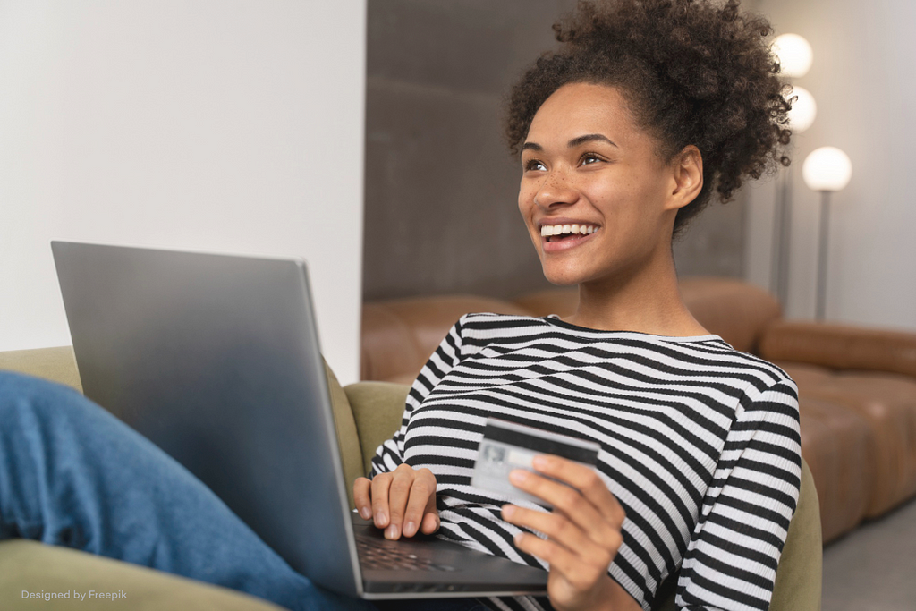 An Image of a lady with a laptop, smiling and holding a credit card, signifying how convenient it is to use the Buy Now Pay Later option when shopping on MyDecorTrade