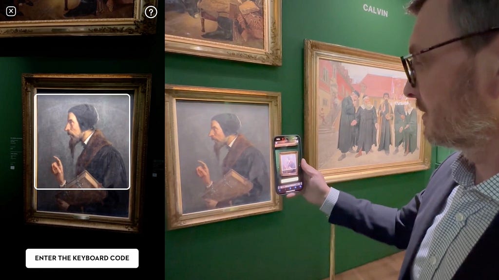 A man holds up a smartphone, using its camera to scan a painting of a bearded figure in a gallery. The phone screen shows an overlay with additional information. To the right, a large painting titled ‘CALVIN’ depicts historical figures