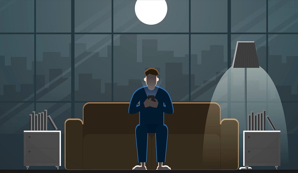 A man looks at his phone late at night.
