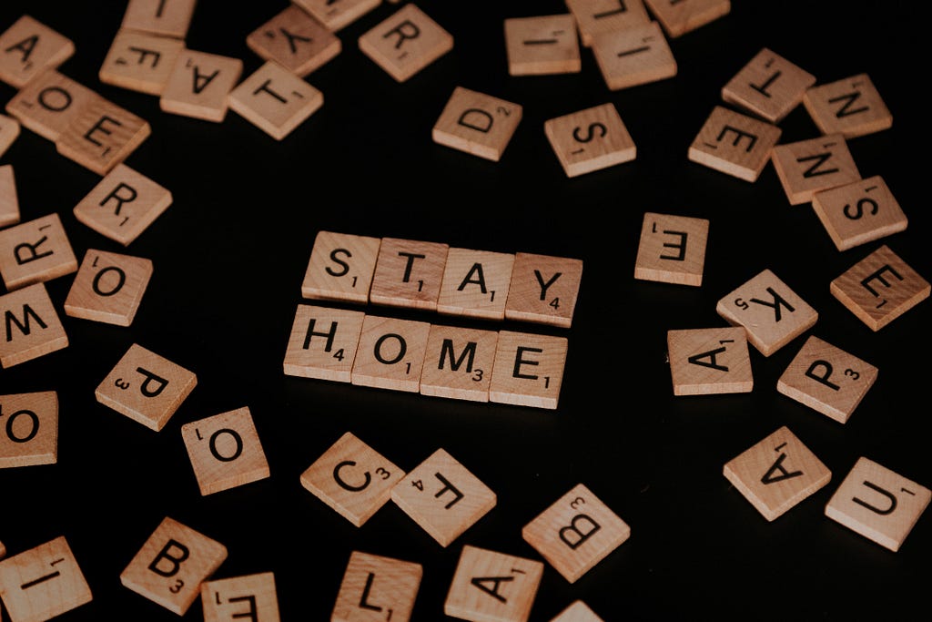 A scrabble board with the words “STAY HOME” spelled out.