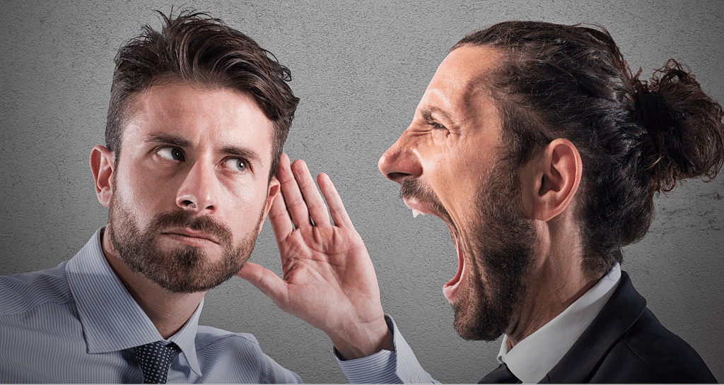 man shouting at auditory impaired man without being heard