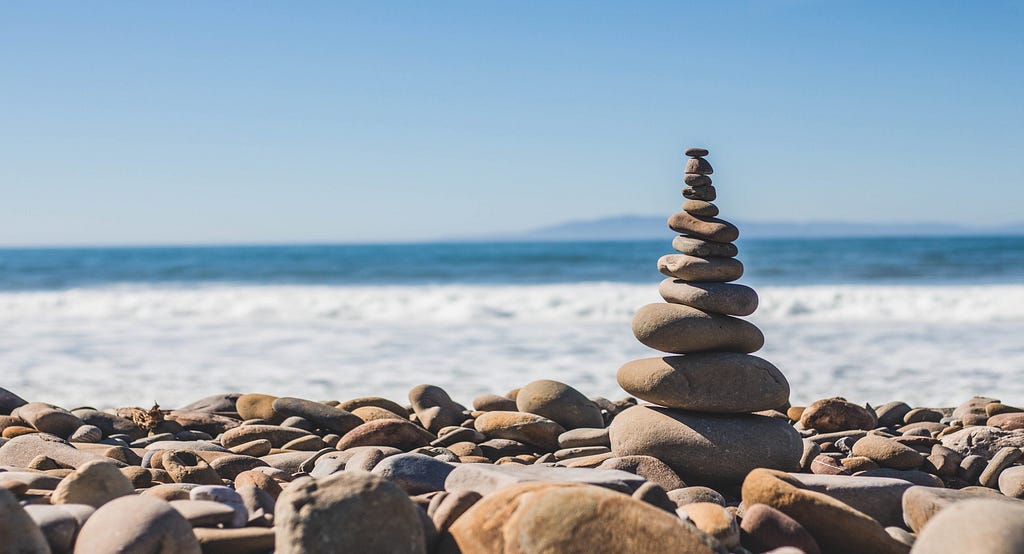 Imagem de Stone balancing (empilhamento de rochas), que representa o equilíbrio, espiritualidade e resiliência.