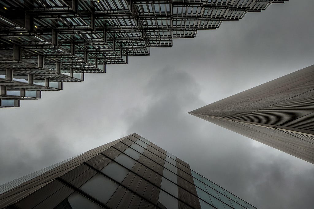 A photo looking up at a gray sky framed by three skyscrapers