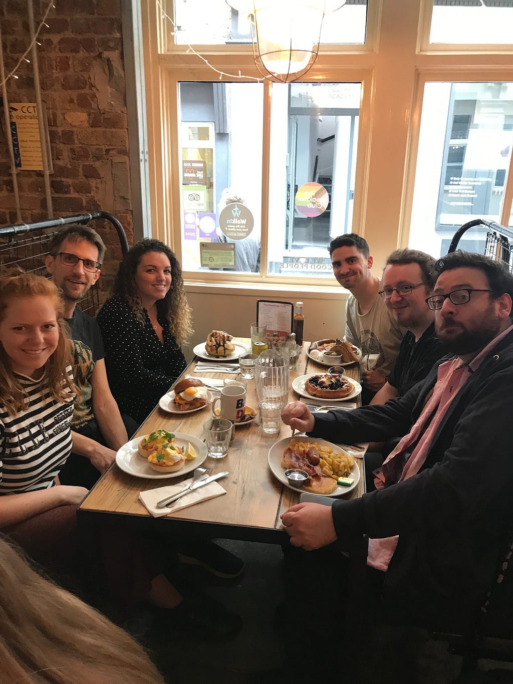 Picture of six people round a table at a restaurant with their breakfasts