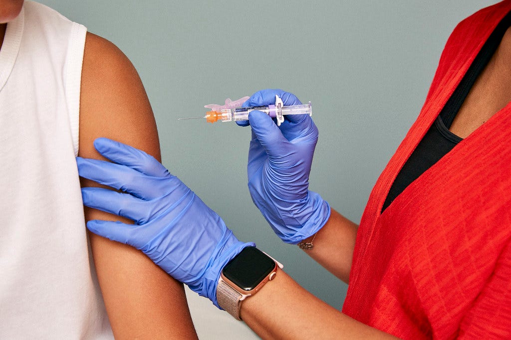 “Closeup of doctor’s hands, vaccine, and arm” by SELF Magazine is licensed with CC BY 2.0.