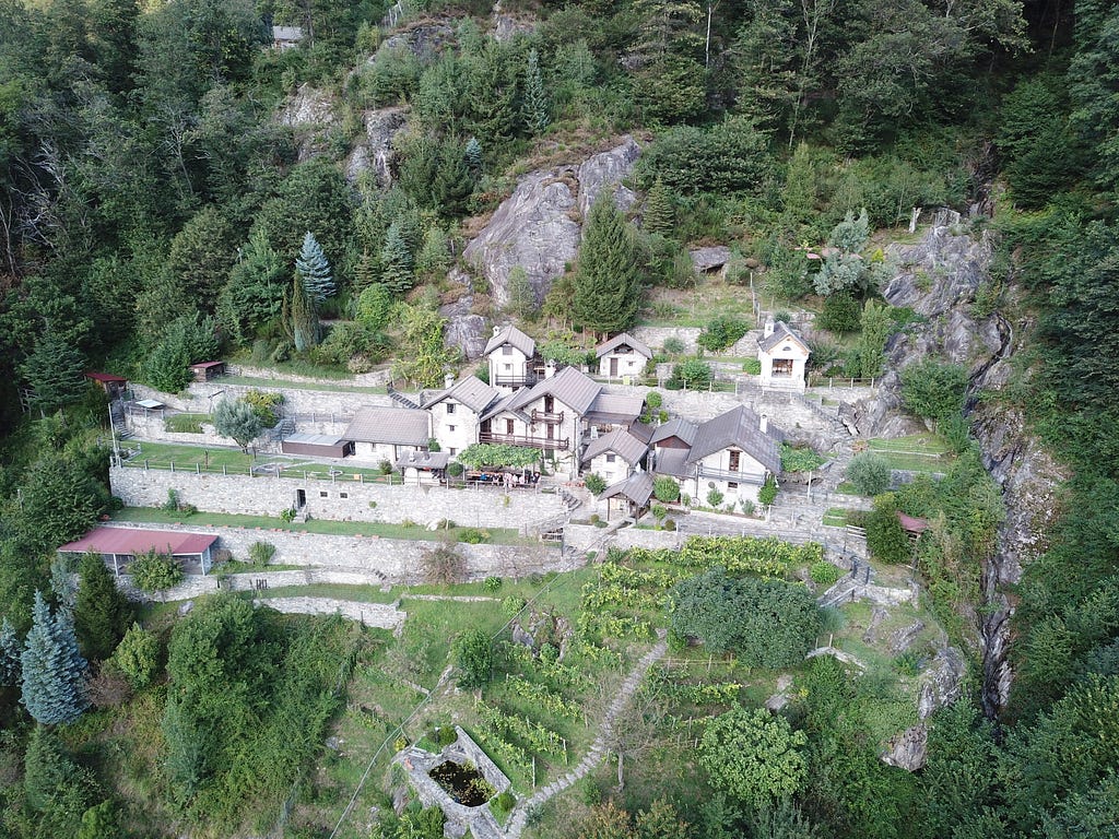 A little town in Verzasca Tal, smartive team members seen from far away sitting at a table.