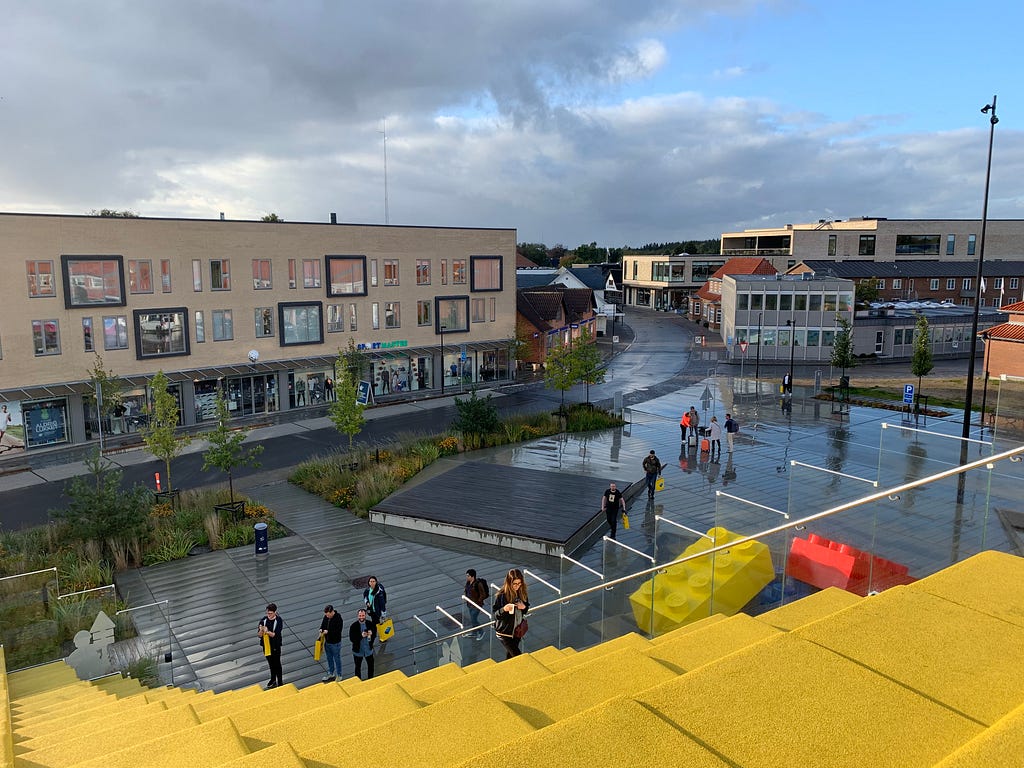 View of some large yellow steps built into a roof, and the road leading away at the bottom, with buildings