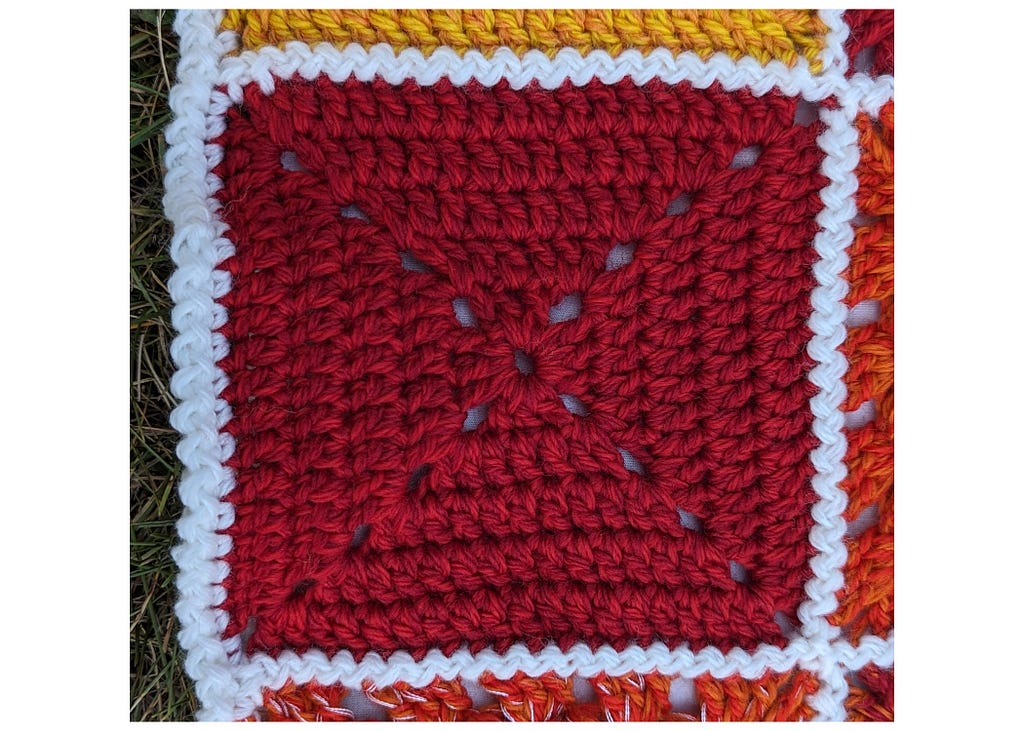 A dark red granny square. The red is comprised of two subtly different shades of yarn.