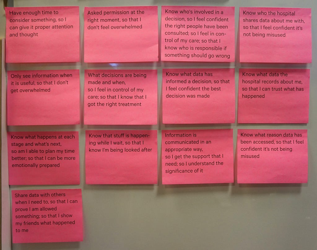 Photograph of a series of pink post it notes with user needs for transparency written on them.