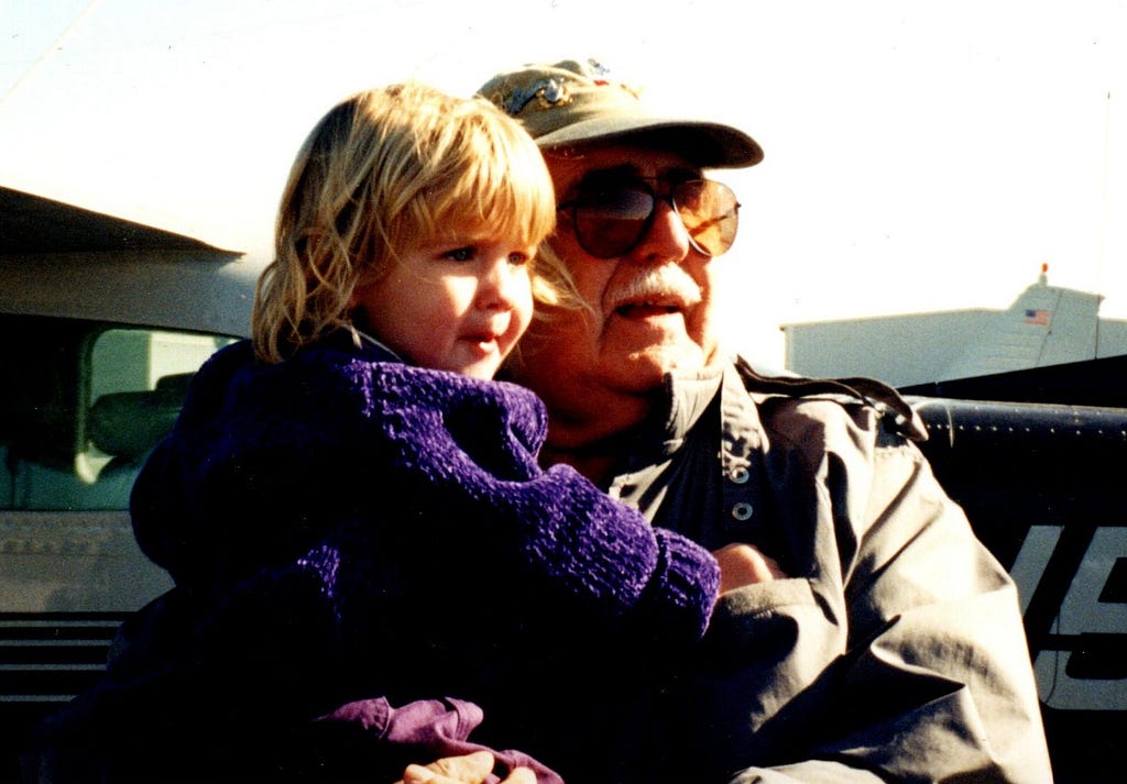 Our  granddaughter, age 2 or 3, held by her Pip, grandfather, at the general aviation airport, Davis Islands, Tampa, Florida.