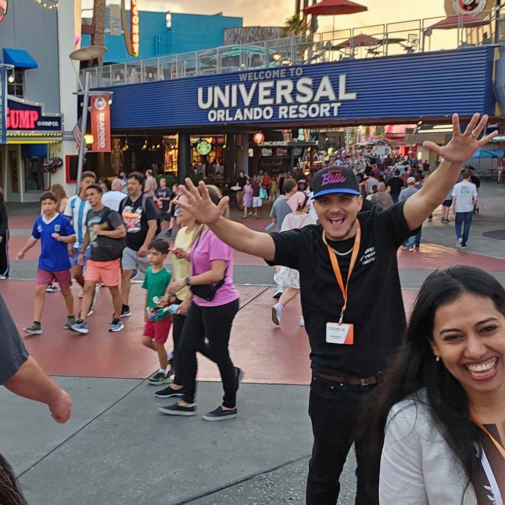 A crowd of tourists in front of a sign announcing the entrance of Universal Orlando Resort.