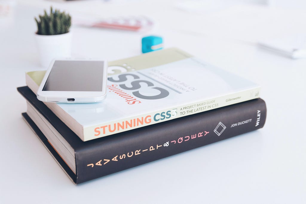 Stack of books titled “Stunning CSS” and “Javascript & JQuery”