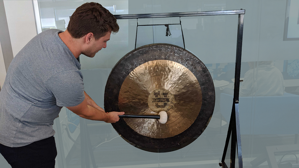 A new Indeedian bangs a gong to signal the completion of their first experiment