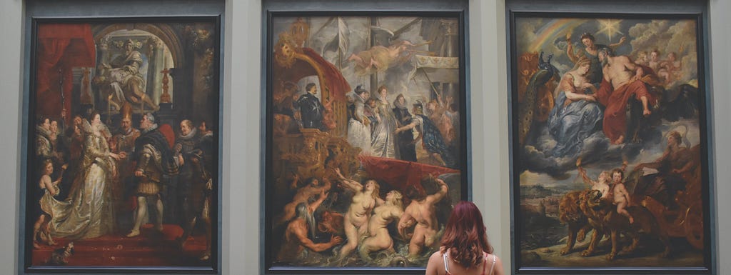 A women looking at classic paintings in a museum